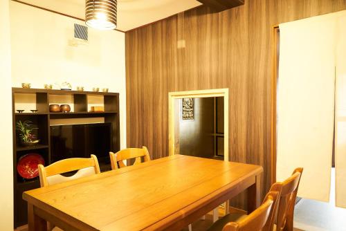 a dining room with a wooden table and chairs at Nagomi TABI-NE in Kanazawa