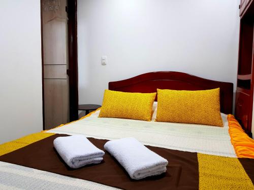 a bedroom with a bed with two towels on it at Posada Dónde Cupeto in Salento