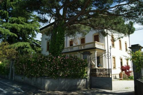 a white house with a fence and flowers at Il Bozzolo Eco Boutique Apartments in Valeggio sul Mincio