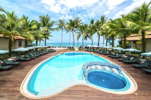una piscina en una terraza con sillas y palmeras en Khaolak Bayfront Resort en Khao Lak