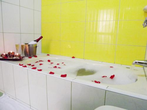 a bath tub with red rose petals on it at Del Castillo Plaza Hotel Pucallpa in Pucallpa