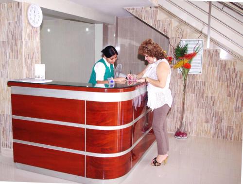 two women standing at a counter in a store at Del Castillo Plaza Hotel Pucallpa in Pucallpa