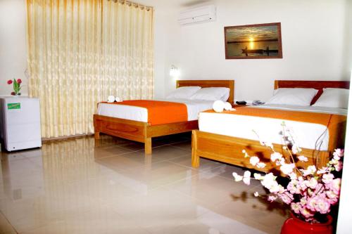 a bedroom with two beds and a vase of flowers at Del Castillo Plaza Hotel Pucallpa in Pucallpa