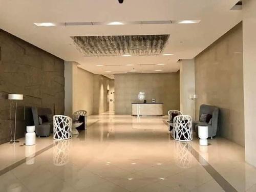 a lobby with chairs and a table in a building at Cubao ManhattanHeights Unit 7EF Tower B, 1BR in Manila