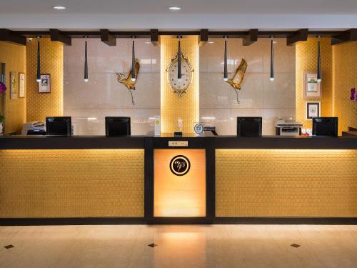 a lobby with a counter with a clock on the wall at Sun Moon Lake Hotel in Yuchi