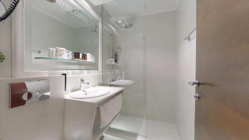 a white bathroom with a sink and a shower at Historic Boutique Hotel Cattaro in Kotor