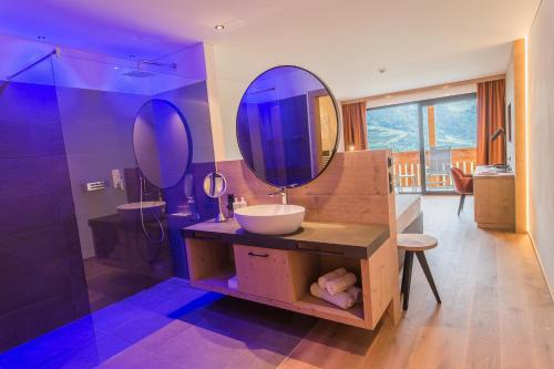a bathroom with a sink and a mirror at Panorama Hotel Himmelreich in Kastelbell-Tschars