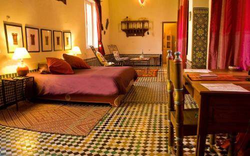 非斯的住宿－里亞德艾巴特酒店，一间卧室设有一张床和一间客厅。