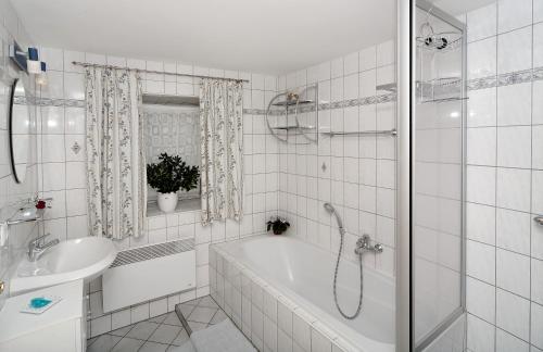 Baño blanco con bañera y lavamanos en Ferienhaus Rachelblick en Kirchberg