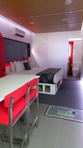 a bedroom with a large bed and a red bench at Room Motels Gympie in Gympie