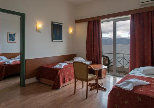 a hotel room with two beds and a balcony at Hotel Kiani Akti in Selianitika