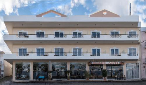 - un grand bâtiment blanc avec des fenêtres et des balcons dans l'établissement Hotel Kiani Akti, à Selianitika