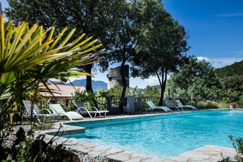 uma piscina com espreguiçadeiras ao lado de um resort em Château de Colombières sur Orb em Colombières