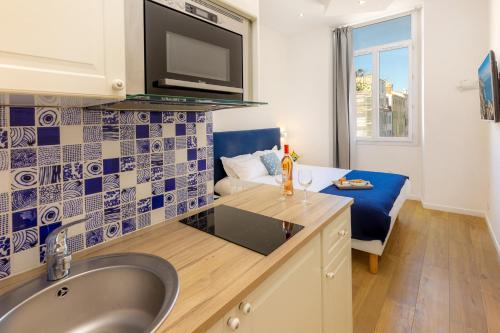 une salle de bain avec lavabo et un salon dans l'établissement Breteuil – Appart au Vieux Port, à Marseille