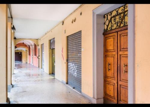 un corridoio vuoto con una porta in un edificio di Portici di via Piella (monolocale) a Bologna