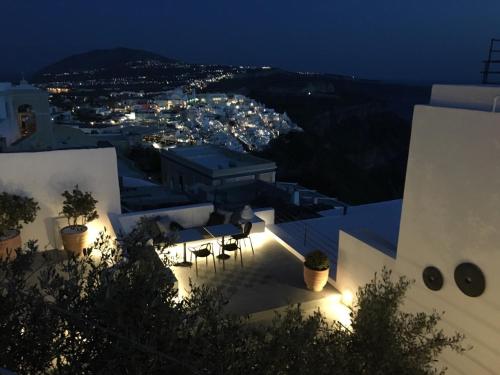 a view of a city at night with lights at Amelot Art Suites in Fira