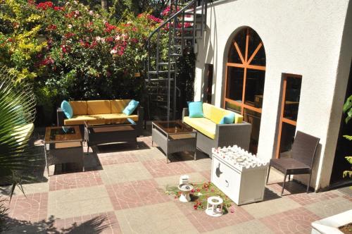 a patio with chairs and tables and flowers at Inn of the Four Sisters in Gonder