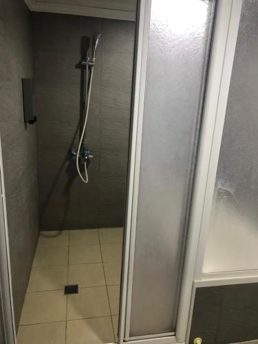 a shower with a glass door in a bathroom at 心園生活旅店 Xin Yuan Hotel in Hsinchu City