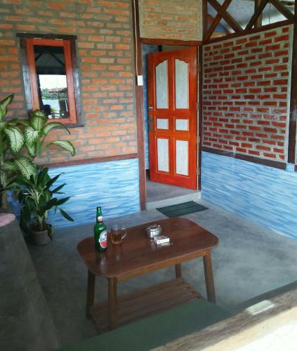 TelukdalemにあるSalty Dog Hostelのテーブル(ボトル1本、グラス2枚付)