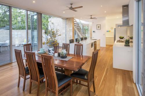 a kitchen and dining room with a wooden table and chairs at Cinque in Dunsborough