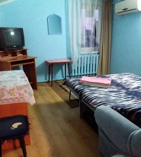 a room with a bed and a table and a tv at улица Прохоровская 12 квартира in Odesa