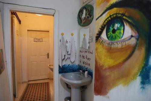 a bathroom with a sink and a painting on the wall at Shantihome in Izmir