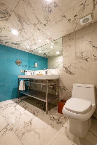 a bathroom with a white toilet and a sink at Hotel Clé Reforma Insurgentes in Mexico City