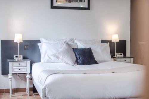 a bedroom with a white bed with two night stands at Chambres d'Hôtes Le Pignié in Lescure-dʼAlbigeois