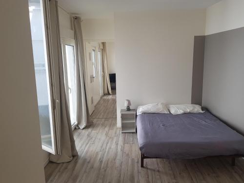 - une chambre avec un lit et un couloir avec une fenêtre dans l'établissement T3 centre Lourdes, à Lourdes