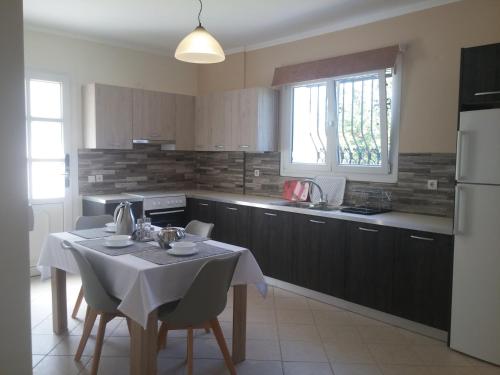 a kitchen with a table with a white table cloth at Maria's Garden in Galatás