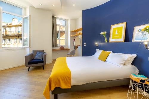 sypialnia z dużym łóżkiem i niebieską ścianą w obiekcie Breteuil – Appart au Vieux Port w Marsylii