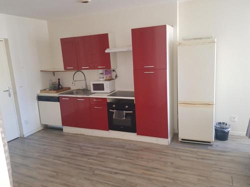 a small kitchen with red cabinets and a microwave at T3 centre Lourdes in Lourdes