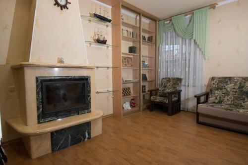 a living room with a fireplace and a chair at Don-Antonio in Krasnodar