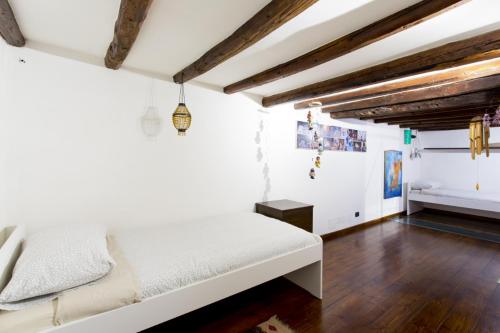 a bedroom with a white bed and wooden floors at Il Drago e la Fenice in Palermo
