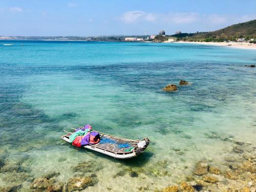 a small boat in the water near a beach at SpoonDrift Hostal Kenting in Nanwan