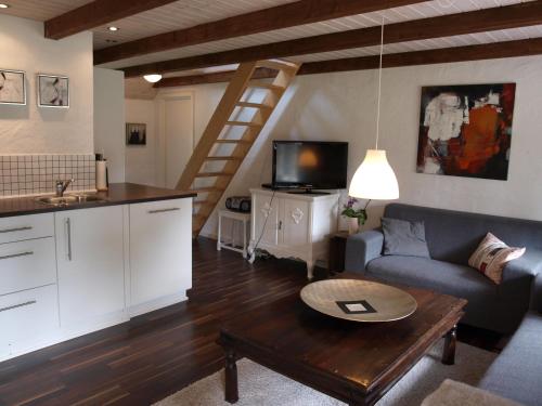 a living room with a couch and a table at Fædrelandet Ferielejlighed & Turridning in Læsø