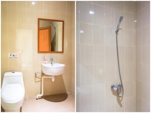 y baño con ducha, aseo y lavamanos. en Aviari Hotel, en Sekupang