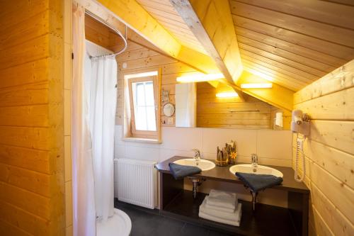 a bathroom with two sinks and a wooden ceiling at Ferienhof Schwehr in Salem