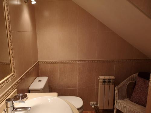 a bathroom with a toilet and a sink at Golden Vedra Residences in Pontevedra
