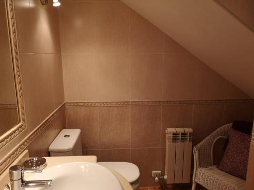 un baño con inodoro y lavabo en Golden Vedra Residences, en Pontevedra