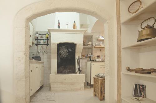 uma cozinha com uma lareira de pedra num quarto em Palazzo Margherita em Cisternino