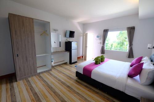 um quarto com uma cama grande e almofadas roxas em Plaloma Resort Lipe em Koh Lipe