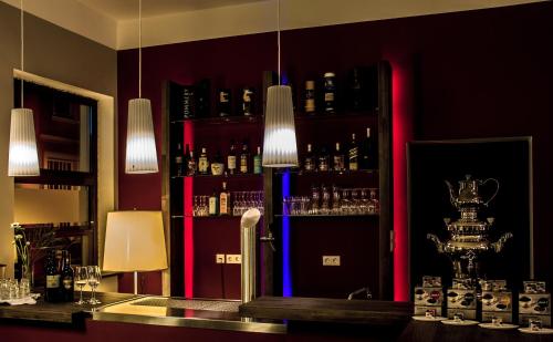 a bar with a counter with alcohol bottles on a shelf at 1891 Hildesheim Boutique Hotel in Hildesheim