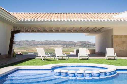 a patio with chairs and a swimming pool at Casa Boquera in Carche