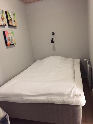 Cette chambre comprend un lit avec des draps blancs. dans l'établissement Hvide Sande Beach Apartments, à Hvide Sande