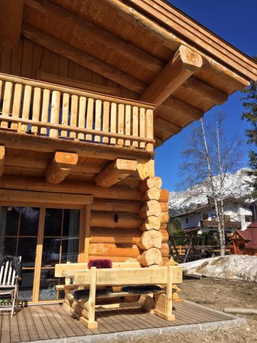 a wooden cabin with a balcony on a deck at Chalet Karin in Hochfilzen