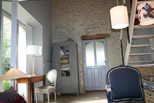 a living room with a staircase and a table and chairs at Le domaine des rouges queues in Châteaudouble