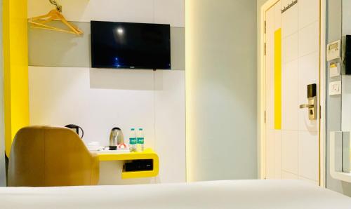 a bedroom with a bed and a tv on the wall at City Empire New Delhi Train Station in New Delhi
