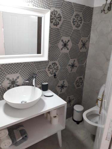 a bathroom with a sink and a toilet and a mirror at Filenia in Hydra