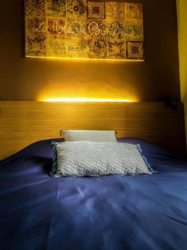 - un lit avec une couette bleue et un oreiller dans l'établissement Un petit coin de paradis, à Saint-Cyprien